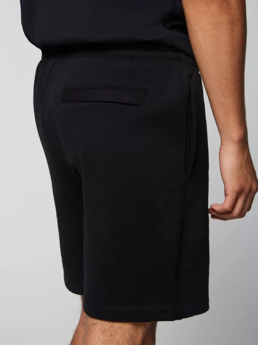 Sergio Tacchini - Línea Esencial: Pantalones Cortos Vintage en Negro Puro 

(Alternativa opcional si requiere variación: Sergio Tacchini - Colección Clásica: Shorts Retro con Detalles en Ébano Urbano)